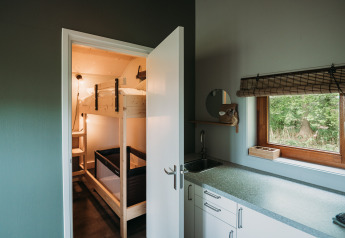 Moderne lodgeinteriør med køkken og køjeseng på Wellness lodge hos Ackerlodges Ruinerwold BV, Holland.