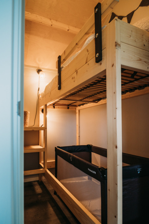 Gemütliche Etagenbett- und Babybett-Kombination in der Wellness Lodge bei Ackerlodges Ruinerwold BV, Niederlande.