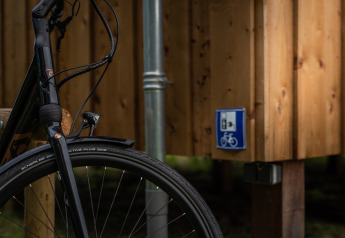 Forhjul på en cykel ved Wellness lodge hos Ackerlodges Ruinerwold BV med skilt om cykelservice i Holland.