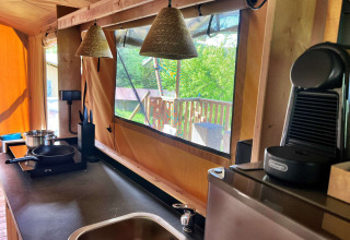 Moderne Küchenbereich im Glamping-Safariazelt bei Per Amore del Vino, Italien, mit Fensterblick.
