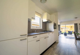 Bright, modern kitchen in Velthorst 4 lodge at Zuiderzee, Netherlands, open to spacious living area and garden.