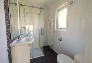 Modern bathroom at Velthorst 4, Zuiderzee, Netherlands, featuring shower, sink, toilet and window.