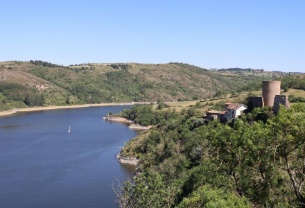 Vista de un lago con un castillo medieval y colinas verdes cerca de Angers, Centre-Val de Loire, Francia.