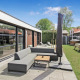 Udendørs opholdsområde ved Eco Lodge hos Uniq Leisure, med moderne sofa, parasol og grøn have i Holland.