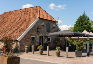 Casa vacacional con techo de tejas y terraza en Holiday Resort 't Schuttenbelt, Overijssel, Países Bajos.