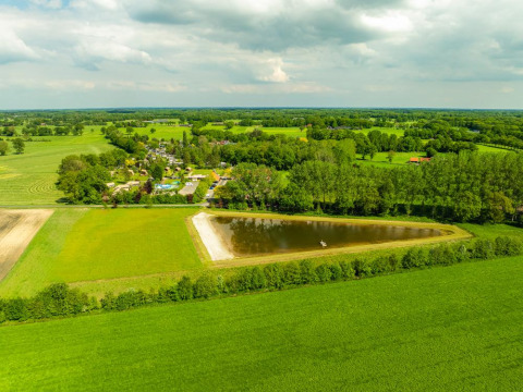 Vista aerea del Holiday Resort 't Schuttenbelt, un villaggio vacanze in Overijssel, Paesi Bassi, tra campi verdi.