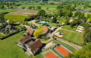 Vue aérienne du Holiday Resort 't Schuttenbelt à Overijssel, Pays-Bas avec terrains de tennis, piscine et tentes.