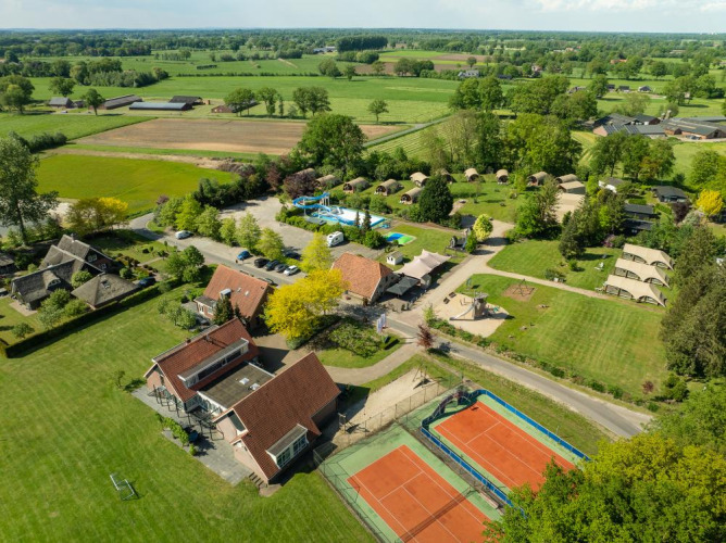 Luftaufnahme vom Ferienpark 't Schuttenbelt in Overijssel, Niederlande, mit Pool, Tennisplätzen und Campingzelten.