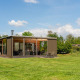 Moderne Woody Lodge Florian ved Holiday Resort 't Schuttenbelt i Holland omgivet af grønne områder.