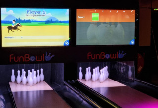 Piste da bowling al coperto con display digitali a FunBowl, attrazione del Vakantiepark de Zeeuwse Parel.