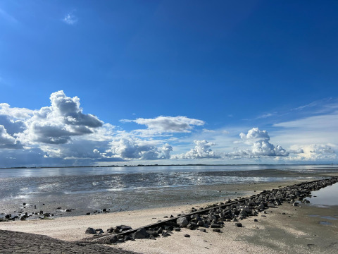 Foto einer Küste bei Ebbe mit großen Wolken bei Vakantiepark de Zeeuwse Parel in Zeeland, Niederlande.