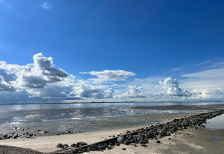 Foto della costa con la bassa marea e nuvole grandi al Vakantiepark de Zeeuwse Parel, Zeeland, Paesi Bassi.