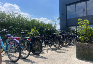 Bicicletas aparcadas frente a un edificio en Vakantiepark de Zeeuwse Parel, en Zeeland, Países Bajos, un día soleado.