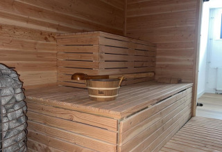 Indendørs sauna med træbænke og varme sten, placeret i Vakantiepark de Zeeuwse Parel i Zeeland, Holland.