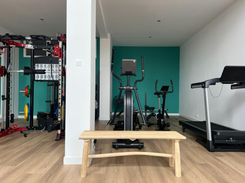 Gimnasio en Vakantiepark de Zeeuwse Parel, Zelanda, con máquinas de ejercicio, banco y cinta de correr.