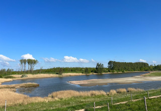 Paisaje natural con lago y vegetación en Vakantiepark de Zeeuwse Parel, Zeeland, Países Bajos.
