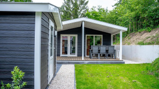 Casa familiar con revestimiento negro y terraza comedor en De Thijmse Berg, Países Bajos, junto a la naturaleza.