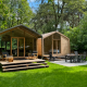 To moderne trælodges med store vinduer og terrasse i skovmiljø ved Wikkelhouse Duo, Beerze Bulten.