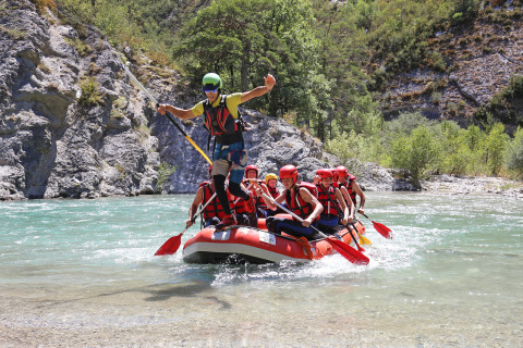 Grupo con cascos y chalecos salvavidas haciendo rafting en aguas claras de Huttopia Gorges du Verdon, Francia.
