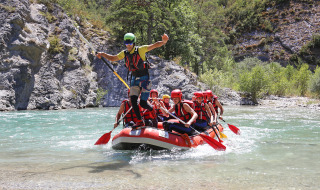Grupo con cascos y chalecos salvavidas haciendo rafting en aguas claras de Huttopia Gorges du Verdon, Francia.