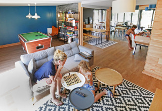Famiglia che si diverte con giochi da tavolo al lounge di Huttopia Baie du Mont St Michel, Bretagna, Francia.