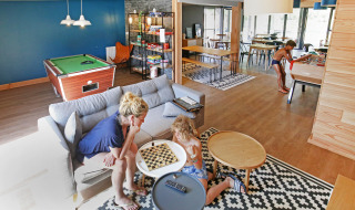 Familie verbringt Zeit beim Spielen im Gemeinschaftsraum im Huttopia Baie du Mont St Michel, Bretagne.