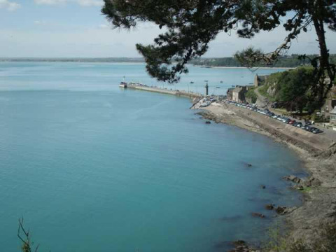 Vista del tranquilo mar azul y la costa en Huttopia Baie du Mont St Michel en Bretaña, Francia.