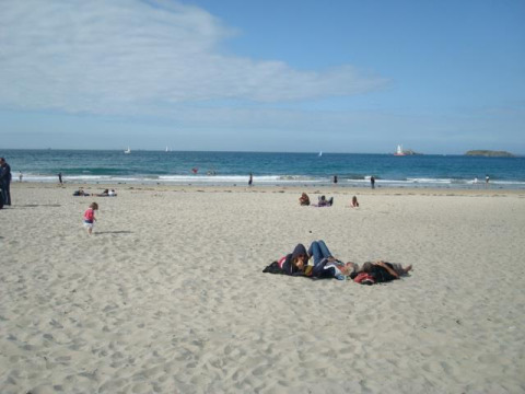 Personas descansando y jugando en la playa de arena de Huttopia Baie du Mont St Michel en Bretaña, Francia.