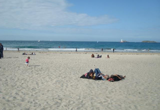 Persone che si rilassano e giocano sulla spiaggia sabbiosa di Huttopia Baie du Mont St Michel in Bretagna, Francia.