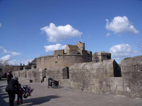 Fortaleza de piedra con torreones redondos en Huttopia Baie du Mont St Michel, Bretaña, Francia.