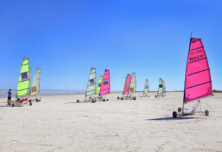 Landsejlads på stranden i Huttopia Baie du Mont St Michel, feriepark i Bretagne, Frankrig, under blå himmel.