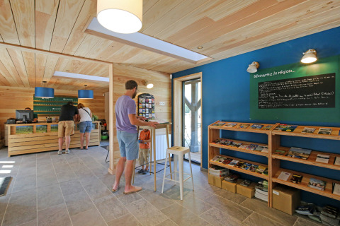 Receptionen hos Huttopia Baie du Mont St Michel i Bretagne, Frankrig, med gæster og informationsbøger.