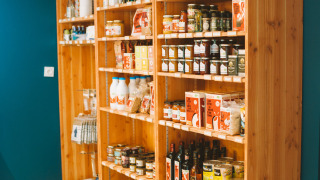 Estantes de madera con productos locales y vino en Huttopia Baie du Mont St Michel, Bretaña, Francia.