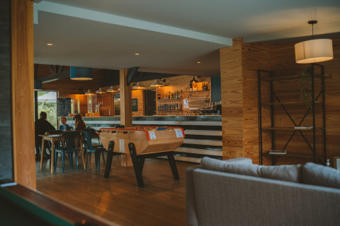 Moderne, gezellige bar en lounge met tafelvoetbal aan Huttopia Baie du Mont St Michel, Bretagne, Frankrijk.