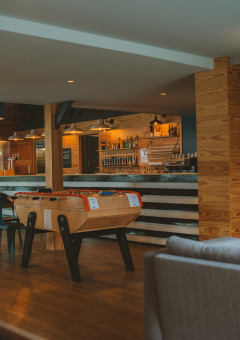 Moderna y acogedora zona de bar con futbolín en Huttopia Baie du Mont St Michel, en la Bretaña, Francia.