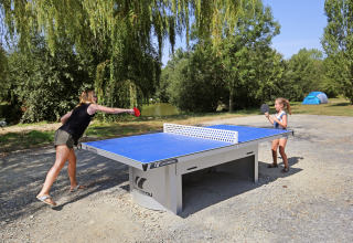 Mor og datter spiller bordtennis udendørs i Huttopia Baie du Mont St Michel, holiday park i Bretagne.