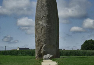 Stort opretstående stenmonument i det grønne landskab nær Baguer Pican, Dol de Bretagne, Bretagne, Frankrig.
