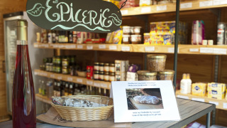 Epicerie im Huttopia Rambouillet, Île de France, mit Wein, Wurst und Spezialitätenregal.