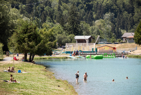 Villeggianti nuotano e si rilassano al lago di Huttopia Bozel en Vanoise, Alvernia-Rodano-Alpi, Francia.