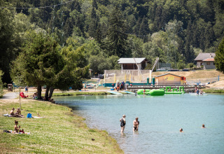 Villeggianti nuotano e si rilassano al lago di Huttopia Bozel en Vanoise, Alvernia-Rodano-Alpi, Francia.