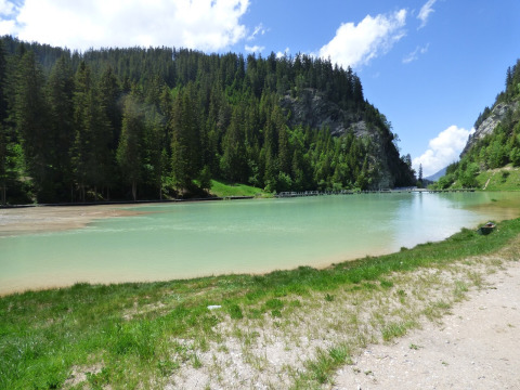 Malereischer See mit klarem Wasser und bewaldeten Hügeln bei Bozel in Auvergne-Rhône-Alpes, Frankreich.