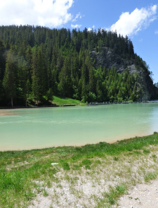 Lago de aguas turquesas rodeado de colinas y bosques cerca de Bozel en Auvergne-Rhône-Alpes, Francia.