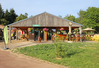 Main wooden building with flowers at Huttopia Etang de Fouché holiday park in Bourgogne, France