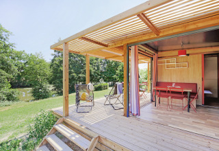 Udendørs terrasse ved en moderne hytte i skovområde på Huttopia Etang de Fouché, Bourgogne-Franche-Comté.