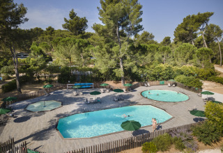 Zwembadzone in vakantiepark Huttopia Fontvieille, tussen pijnbomen in Provence-Alpes-Côte d’Azur, Frankrijk.