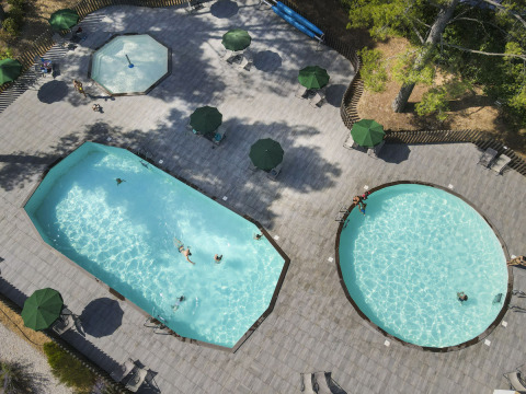 Vista aérea de piscinas y zona de relax en el parque vacacional Huttopia Fontvieille en Provenza-Alpes-Costa Azul, Francia.