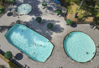 Vista aerea delle piscine e dell’area relax presso il villaggio Huttopia Fontvieille in Provenza-Alpi-Costa Azzurra, Francia.