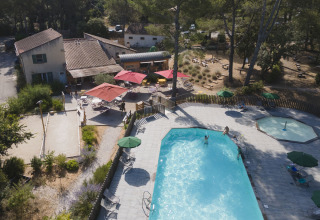 Luchtfoto van vakantiepark Huttopia Fontvieille in Provence met zwembad, terras en parasols.
