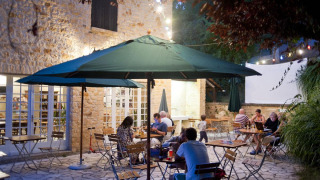 Zona de comedor al aire libre en Huttopia Sarlat, parque vacacional en Nouvelle-Aquitaine, Francia, de noche.