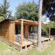 Træhytte med terrasse og havemøbler omgivet af træer i naturlige omgivelser ved Chalet Ottawa.